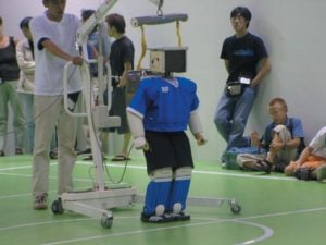 Abbildung 2: Aller Anfang ist schwer: In der Humanoid-League tüftelt man noch am freien Stehen und Laufen ohne umzufallen, während Sonys Roboterhunde (die Aibos) ein paar Meter weiter bereits sehenswerten Fußball spielen.