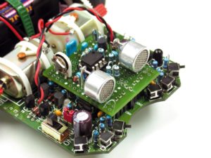 Abbildung 8: Das Buch "Mehr Spaß mit Asuro" enthält eine Erweiterungsplatine für zwei Ultraschall-Sensoren (vorne, mit Gitter). Es erscheint zeitgleich mit dieser Ausgabe des Linux-Magazins.