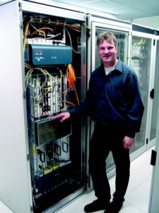 Abbildung 2: Jörg Hennig, Technik-Vorstand bei der 1&1-Tochter Schlund+Partner, vor dem Cisco-1200-Router zum DeCIX-Knoten in Frankfurt.