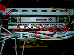 Abbildung 2: Der Compaq-Storageworks-SAN-Switch mit Display und Bedienfeld für Konfiguration und Abfrage von Statusinformationen ist in der Mitte zu bestaunen. Die roten Kabel führen zu den Alphas.