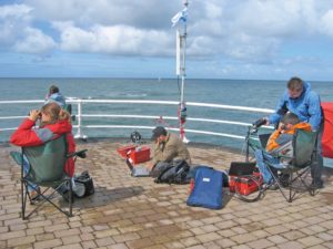 Abbildung 4: Segelcrew an Land: Das Roboat-Team kontrolliert die Fahrt des Mini-Seglers am Laptop und mit dem Feldstecher.
