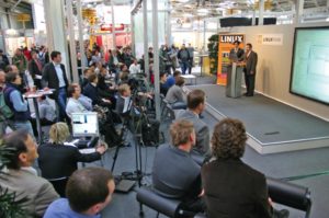 Abbildung 2: Auf der Bühne des Linuxforums in Halle 5 gibt es stündlich wechselnde Vorträge zu Linux und Open Source. Daheimgebliebene können das Programm live per Videostream verfolgen.