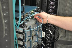 Abbildung 1: Statt pro Server ein Netz- und ein Stromkabel zu legen, erlauben Bladegehäuse mehrere Server pro Kabel, so wie bei dem abgebildeten Chassis mit zwei verbauten Fibrechannel-Extendern und zwei externen Switches mit bis zu 20 Ports.