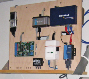 Abbildung 9: Elektronische Kellerkinder des Autors: Das weiße Kästchen ist der Sheevaplug-Computer. Das Mobiltelefon links oben dient der SMS-Alarmierung.