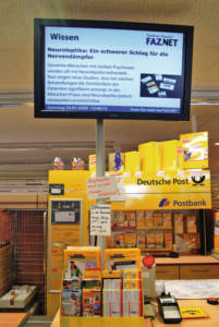 Abbildung 1: Aus dem Auftritt der Deutschen Post nicht mehr wegzudenken: Die wartenden Kunden versucht der Konzern mit großen Werbetafeln zu unterhalten.
