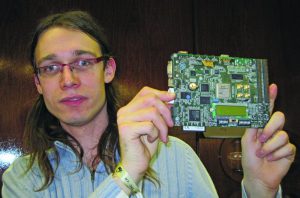 Abbildung 2: Der gerade erst fertig gewordene Chipdesigner Sébastien Bourdeauducq hält seinen komplett offenen Visual Synthesizer in die Höhe, ein SoC mit dem Board Xilinx ML401. Jetzt entwirft er ein eigenes Board.
