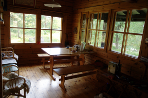 Abbildung 8: Innen präsentiert sich das Holzhaus eher spartanisch. Auf dem Tisch stehen noch die Teekannen.