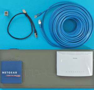 Abbildung 3: Die zwei kleinen und der große Gigabit-Switch in der unteren Bildhälfte bewirken um rund 20 Mikrosekunden längere RTTs, das blaue 50-Meter-Kabel 500 Nanosekunden, das schwarze 0,5-Meter-Kabel 5 Nanosekunden und der 4 Zentimeter lange Adapter 0,2 Nanosekunden längere Laufzeiten.