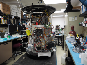 Abbildung 4: Blick ins Innere des ESP. Oberhalb des grünen Maskottchens Lucky sind mehrere Spindelmotoren erkennbar, die Mechanikkomponenten zum Handling und zur Analyse von Wasserproben antreiben.