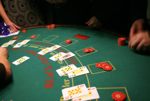 Abbildung 1: Der Blackjack-Dealer hat sich eine offene Karte und jedem der sechs Spieler am Tisch jeweils zwei Karten zugeteilt.