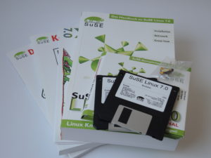 Abbildung 1: In der Schachtel von SuSE Linux&nbsp;7.0 befanden sich unter anderem drei gedruckte Handb&uuml;cher, eine Schnellinstallationsanleitung, sechs CDs, zwei Disketten und ein Tux als Ansteckpin.