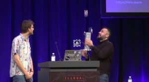 Abbildung 1: Open Source bei der ESA live auf der Bühne des 38C3: Manthos Papamatthaiou und Paul Koetter demonstrieren das orbitale Release eines auf Open Hardware basierenden Mini-Cube-Satelliten.