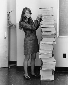 Abbildung 2: Margaret Hamilton, Leiterin der Software Engineering Division, steht sichtlich stolz neben dem Papierstapel des ausgedruckten Codes der Apollo-Mission &ndash; sie war der erste Programmierer bei der NASA &uuml;berhaupt, nicht nur die Erste. Quelle: NASA, CC-0