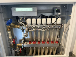 Abbildung 2: Die fertige Installation: Oben gibt es eine Schuko-Steckdose f&uuml;r die vorhandene Hutschiene sowie einen HmIP-FALMOT-C12 mit Stellmotoren f&uuml;r die Ventile der einzelnen Heizkreisl&auml;ufe.