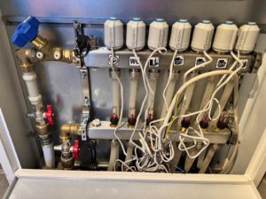 Abbildung 3: Tohuwabohu: So sah der Verteiler der Heizung vorher aus. Gut zu erkennen sind die alten Stellmotoren, die direkt an 230&nbsp;Volt angeschlossen waren, allerdings alles andere als sauber.